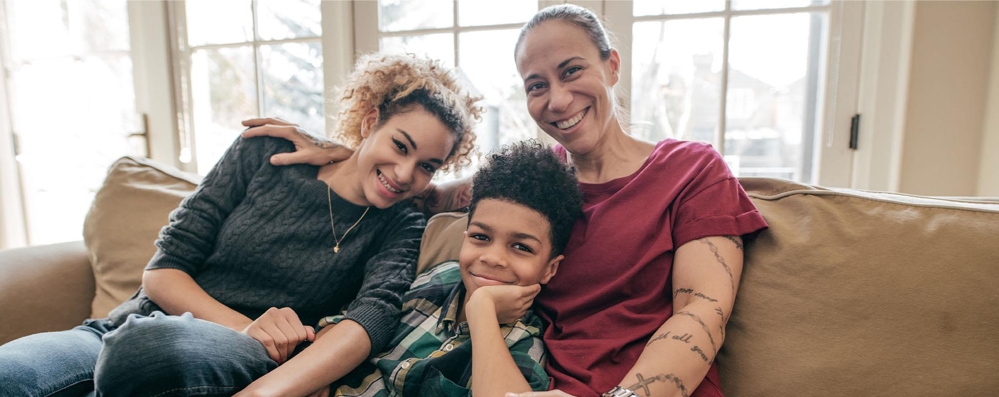 family sitting on couch hugging